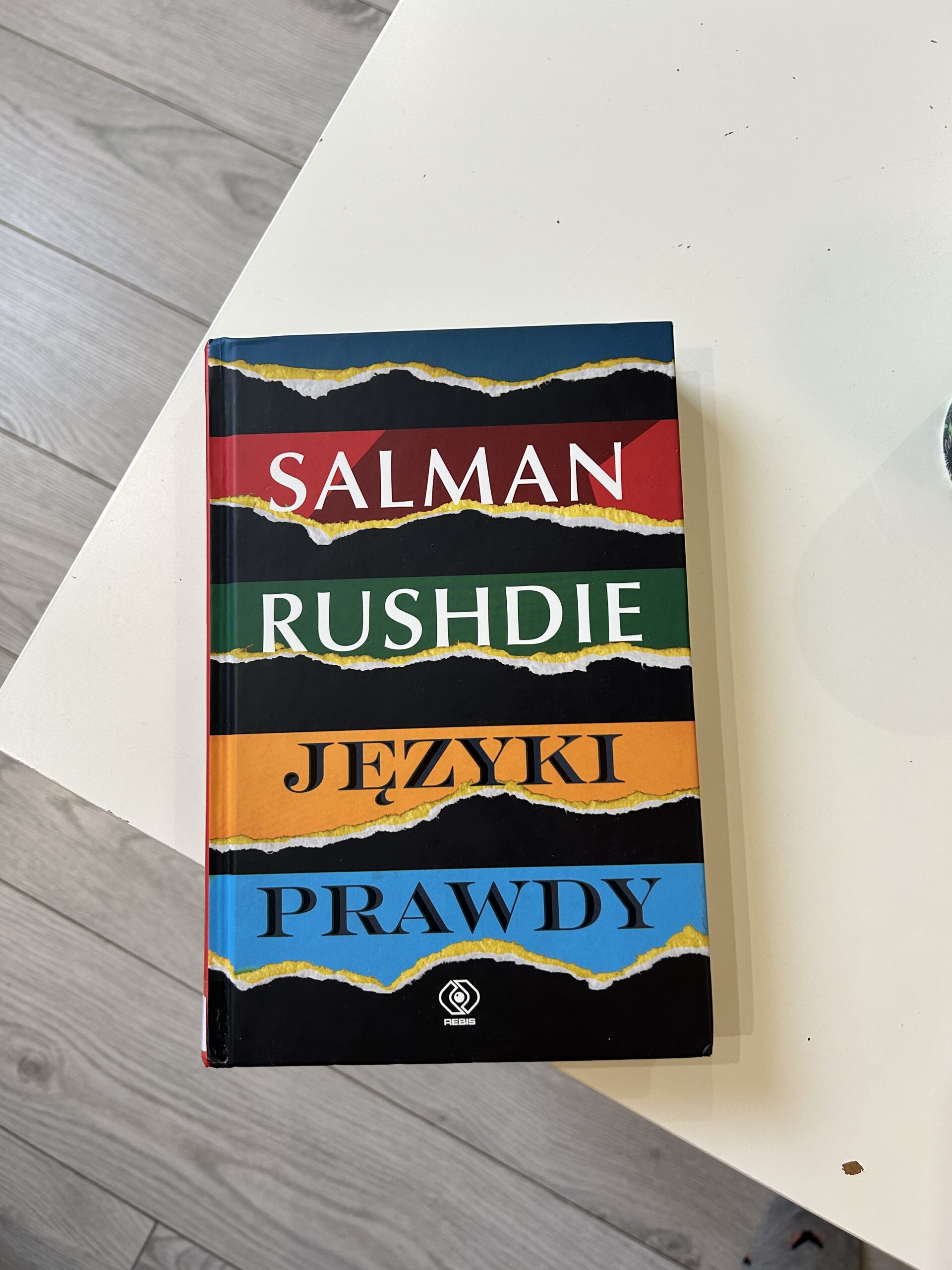 Kolorowe zdjęcie. Książka leży na stole.